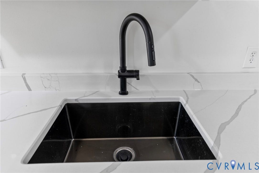 1708 Decatur Street, Swansboro, Richmond, VA 23224 Undermount deep-basin sink with a matte black high-arc pull-down faucet, set into a stone-finish countertop with an integrated backsplash