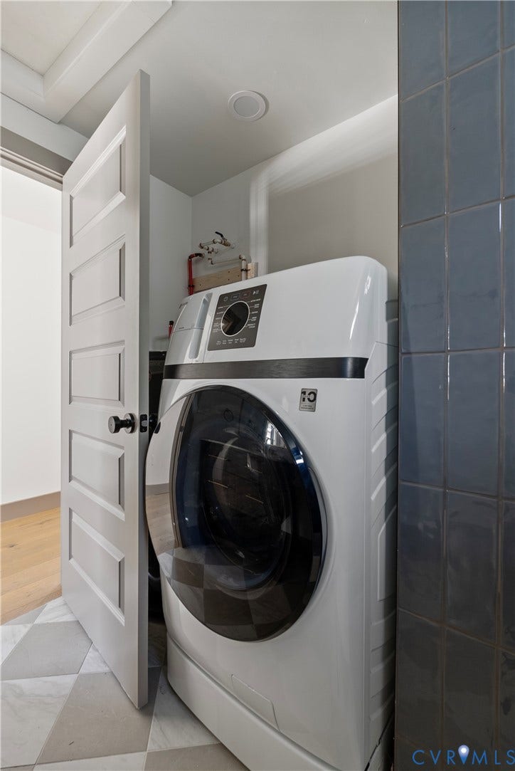 1708 Decatur Street, Swansboro, Richmond, VA 23224 Utility area featuring geometric tile flooring, vertical dark-toned wall tiling, and a white five-panel interior door with matte black hardware