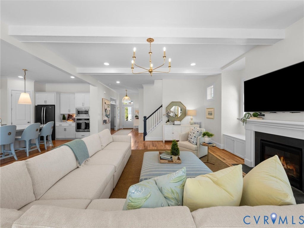 1412 Ascot Hill Terrace, Midlothian, VA 23112 Open-concept interior featuring beamed ceilings, white shaker-style cabinetry, wood flooring, a fireplace with a mantel, and a multi-arm chandelier