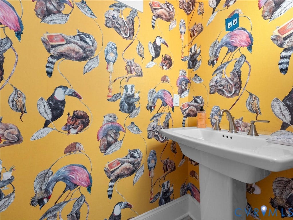 1412 Ascot Hill Terrace, Midlothian, VA 23112 Pedestal sink with a polished metal dual-handle faucet, accented by bold, illustrative botanical and wildlife wallpaper