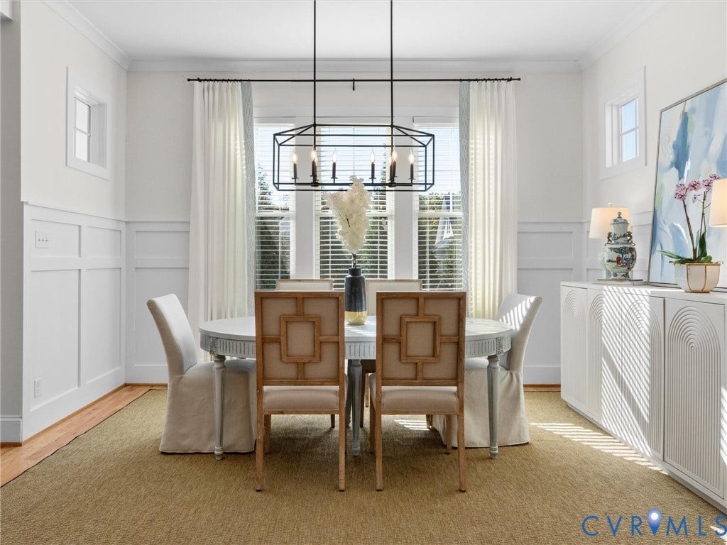 1412 Ascot Hill Terrace, Midlothian, VA 23112 Dining space featuring white wainscoting, a black iron rectangular chandelier, triple window configuration, and white built-in cabinetry with arched detailing