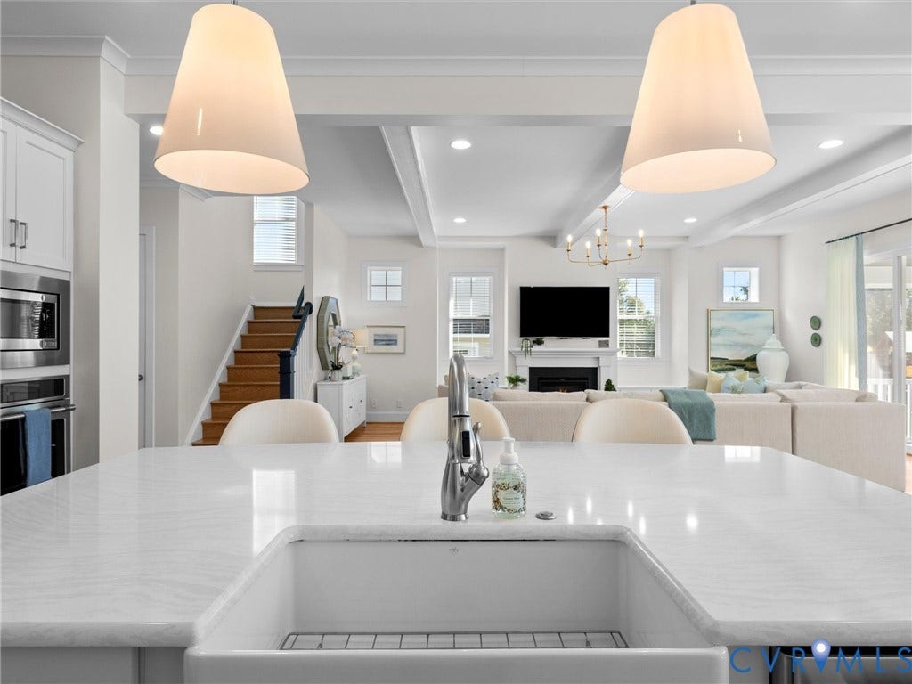 1412 Ascot Hill Terrace, Midlothian, VA 23112 Kitchen island featuring a white stone countertop, undermount farmhouse sink, and high-arc faucet, complemented by oversized pendant lighting and coffered ceilings