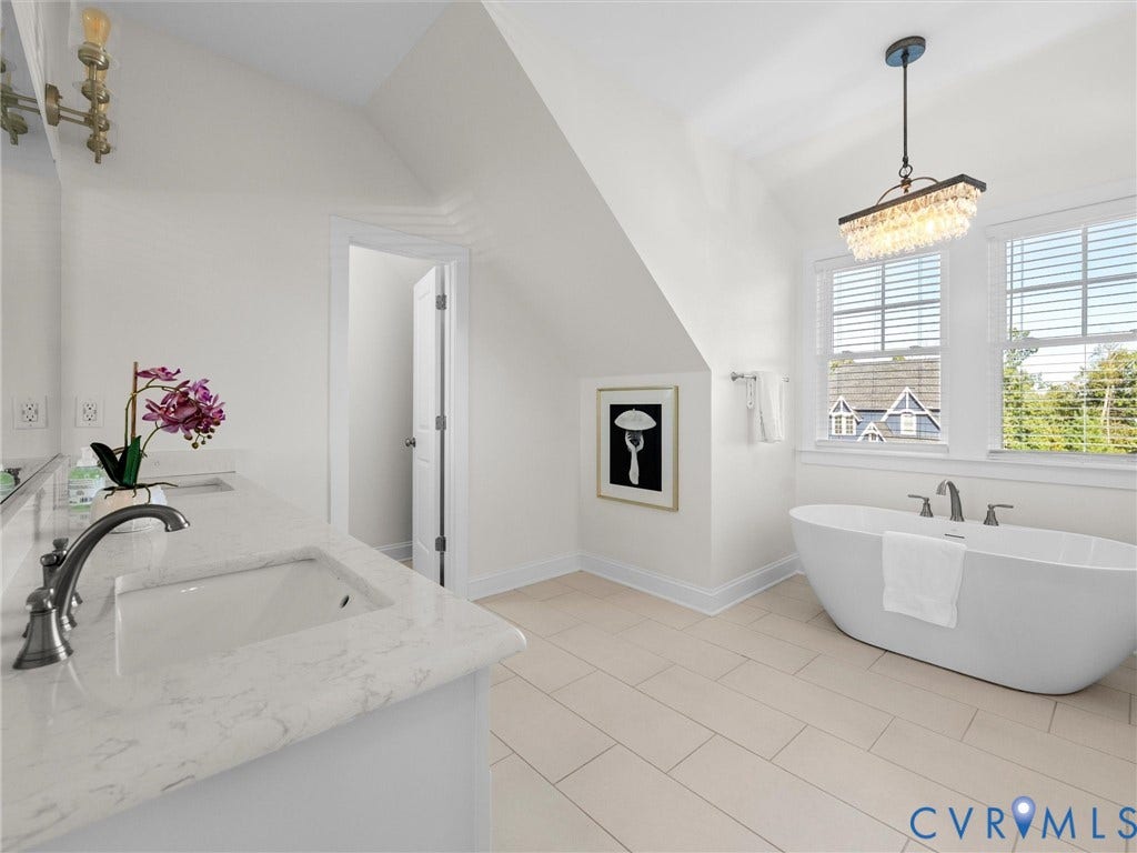 1412 Ascot Hill Terrace, Midlothian, VA 23112 Freestanding soaking tub with a deck-mounted faucet, rectangular undermount sink, stone-surface countertop, vaulted ceiling, and tiered crystal chandelier
