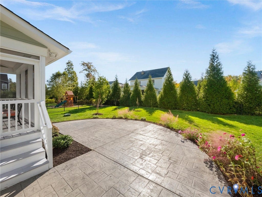 1412 Ascot Hill Terrace, Midlothian, VA 23112 Backyard featuring a stamped concrete patio, screened porch, perimeter metal fencing, and mature evergreen privacy screening
