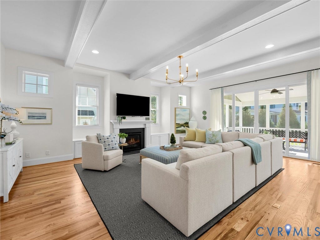 1412 Ascot Hill Terrace, Midlothian, VA 23112 Open-concept living space featuring wood-finish flooring, vaulted ceilings with exposed beams, a fireplace with a mantel, and large sliding glass doors providing access to a screened porch