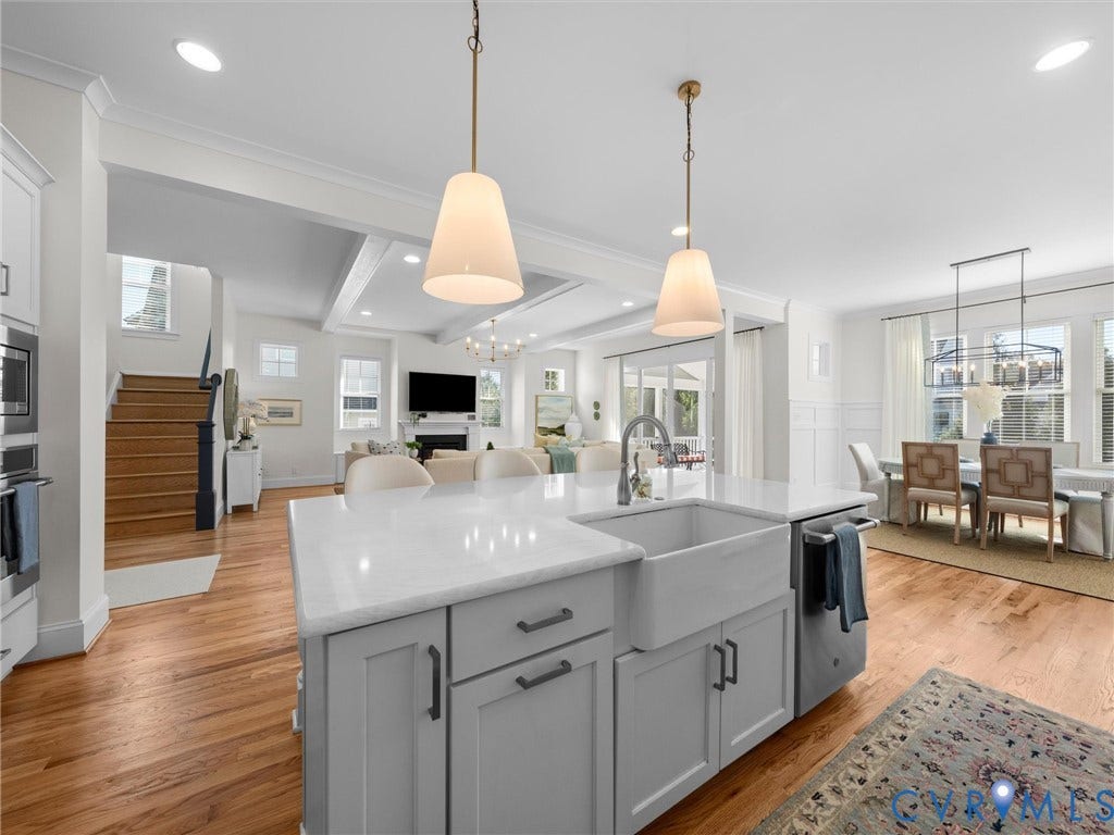 1412 Ascot Hill Terrace, Midlothian, VA 23112 Kitchen island featuring a farmhouse sink, quartz countertop, and matte hardware, complemented by wood-finish flooring and dual pendant lighting