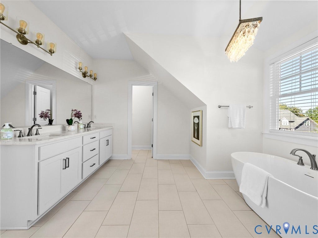 1412 Ascot Hill Terrace, Midlothian, VA 23112 Dual-sink vanity with stone countertop, freestanding soaking tub, large-format tile flooring, rectangular wall mirror, and crystal chandelier fixture