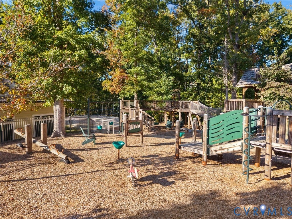 1412 Ascot Hill Terrace, Midlothian, VA 23112 Backyard playground featuring a wooden multi-level climbing structure, slide, teeter-totter, and fenced pool area surrounded by mature trees