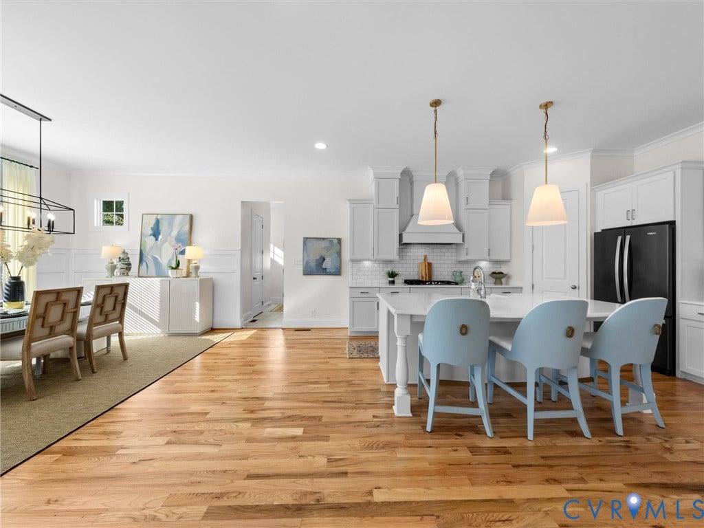 1412 Ascot Hill Terrace, Midlothian, VA 23112 Open kitchen and dining area featuring wood-finish flooring, white shaker-style cabinetry, a stone-topped island with seating, and pendant lighting