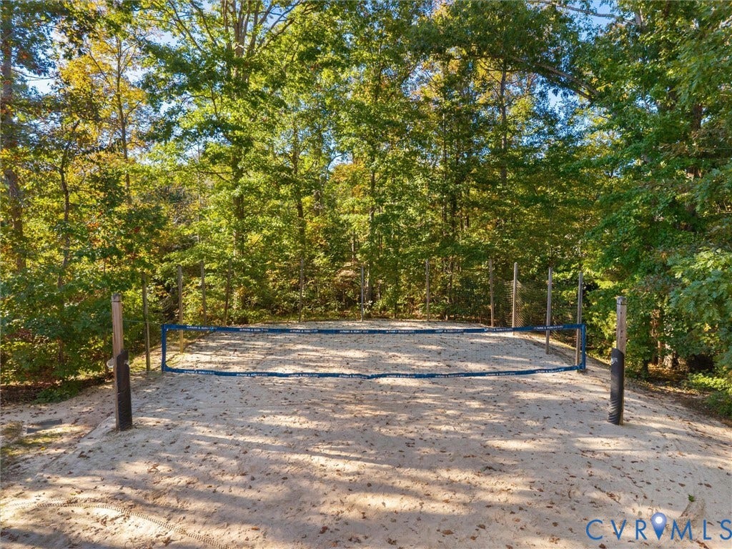 1412 Ascot Hill Terrace, Midlothian, VA 23112 Sand volleyball court featuring a permanent net system, vertical support posts, and perimeter fencing surrounded by mature trees