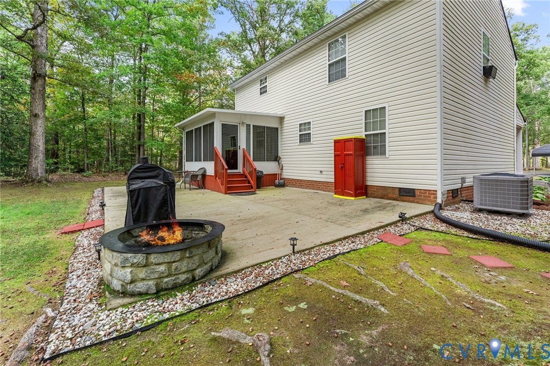 17030 Courtney Road, Reedy Church District, Hanover, VA 23069 Concrete patio featuring a stone-faced fire pit, screened-in porch with painted wood stairs, and vinyl siding exterior