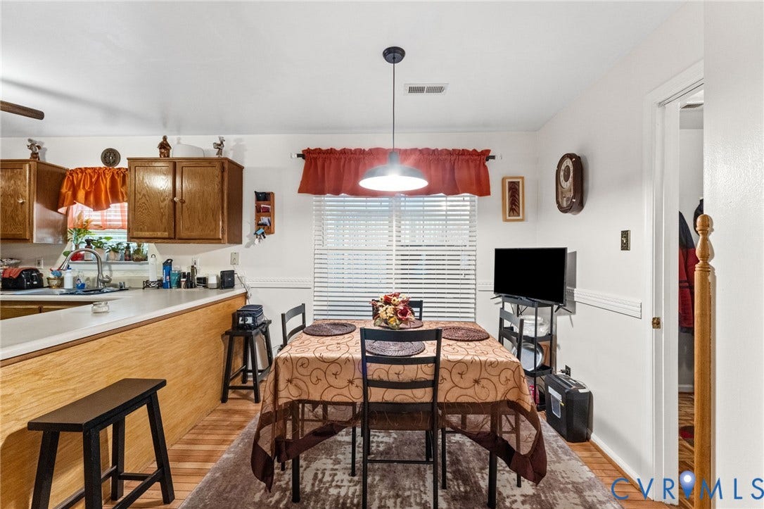 17030 Courtney Road, Reedy Church District, Hanover, VA 23069 Kitchen featuring wooden cabinetry, a wrap-around peninsula, wood-finish flooring, chair rail molding, and a central pendant light fixture