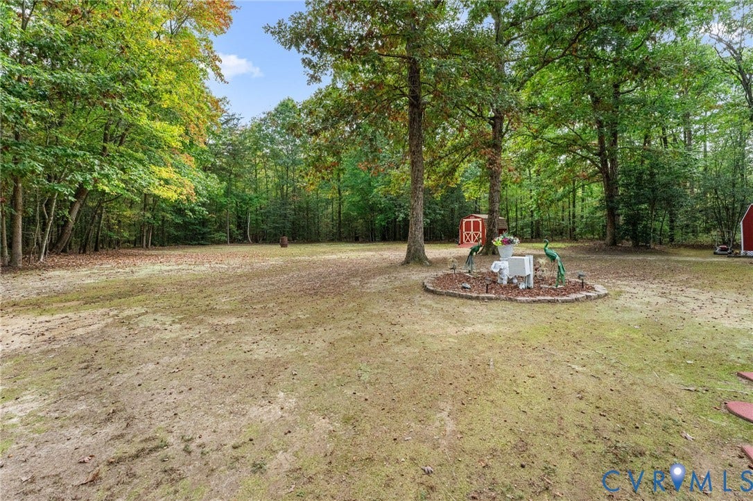 17030 Courtney Road, Reedy Church District, Hanover, VA 23069 Expansive grounds featuring mature shade trees, a stone-bordered landscape bed, and a detached storage structure