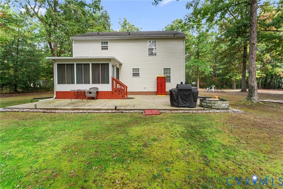 17030 Courtney Road, Reedy Church District, Hanover, VA 23069 Rear exterior featuring light-toned vinyl siding, a screened-in porch with wood-style steps, a concrete patio, and a stone-encased fire pit