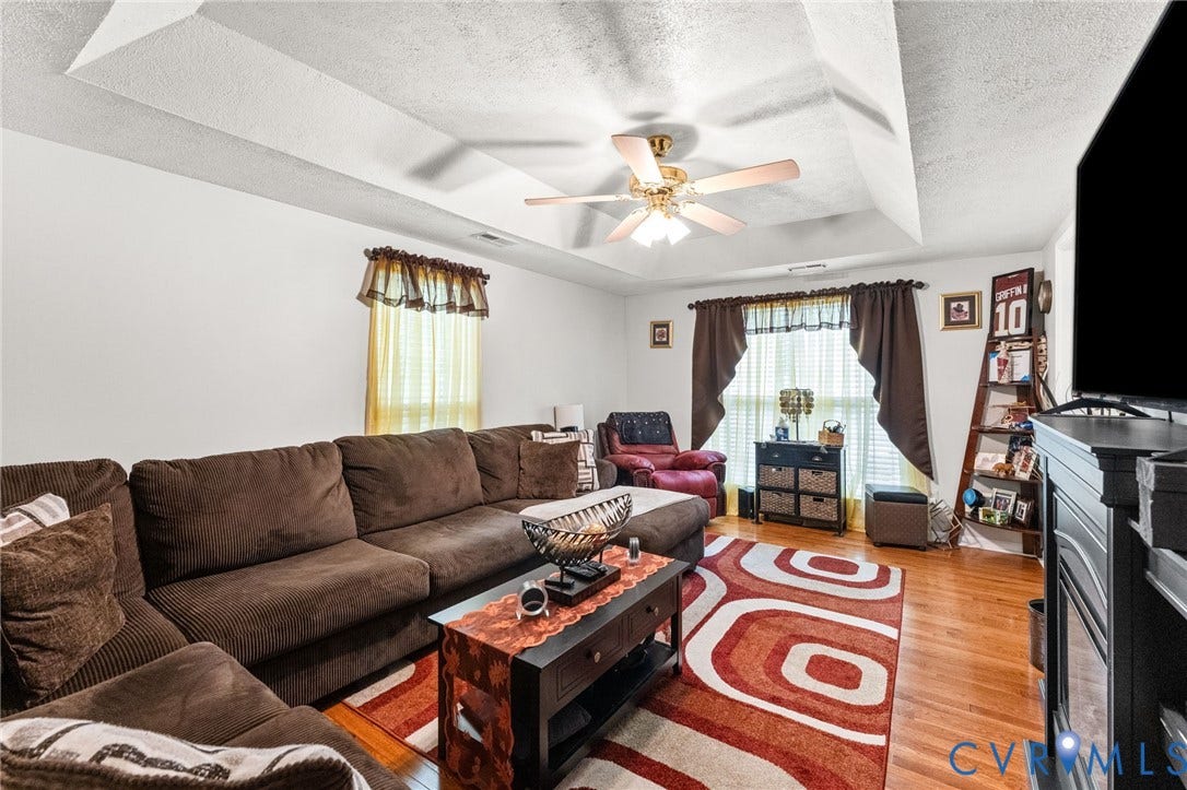 17030 Courtney Road, Reedy Church District, Hanover, VA 23069 Living area featuring a tray ceiling, wood-finish flooring, and a multi-blade ceiling fan with integrated lighting
