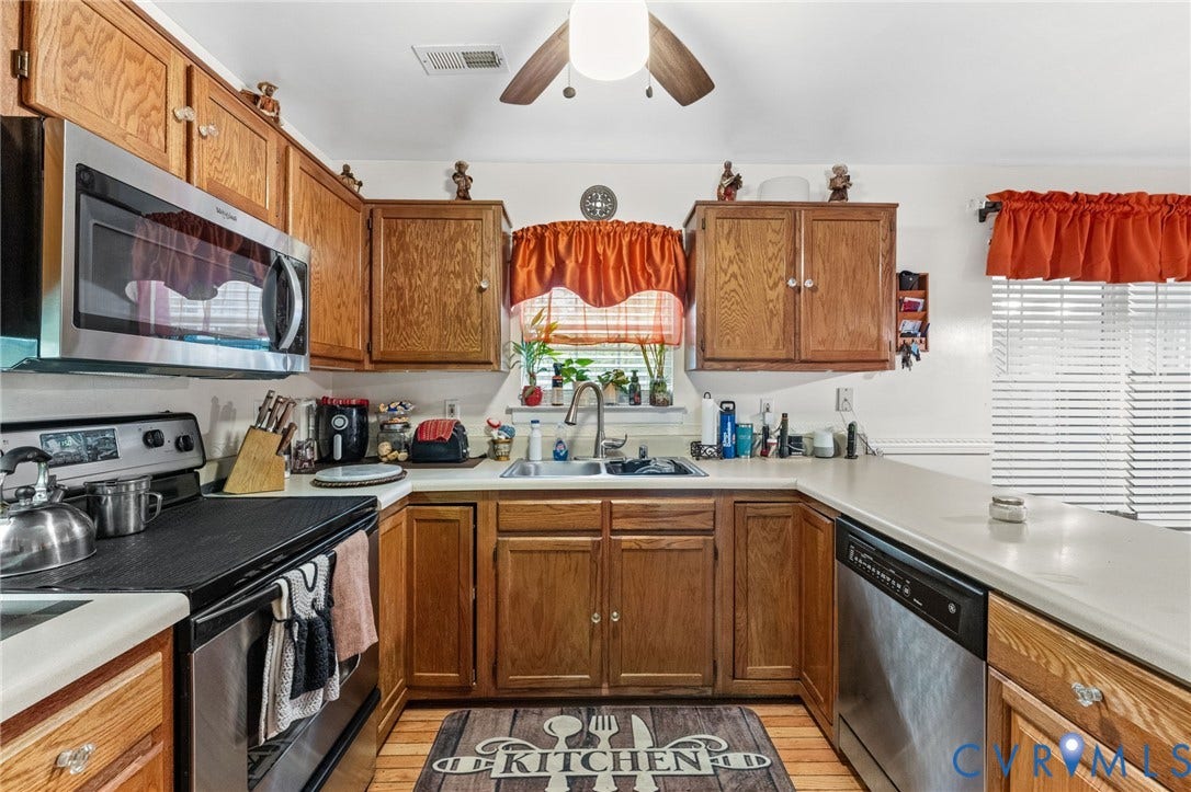 17030 Courtney Road, Reedy Church District, Hanover, VA 23069 Kitchen featuring wood cabinetry, stainless steel appliances, dual-basin sink with arched faucet, and solid-surface countertops
