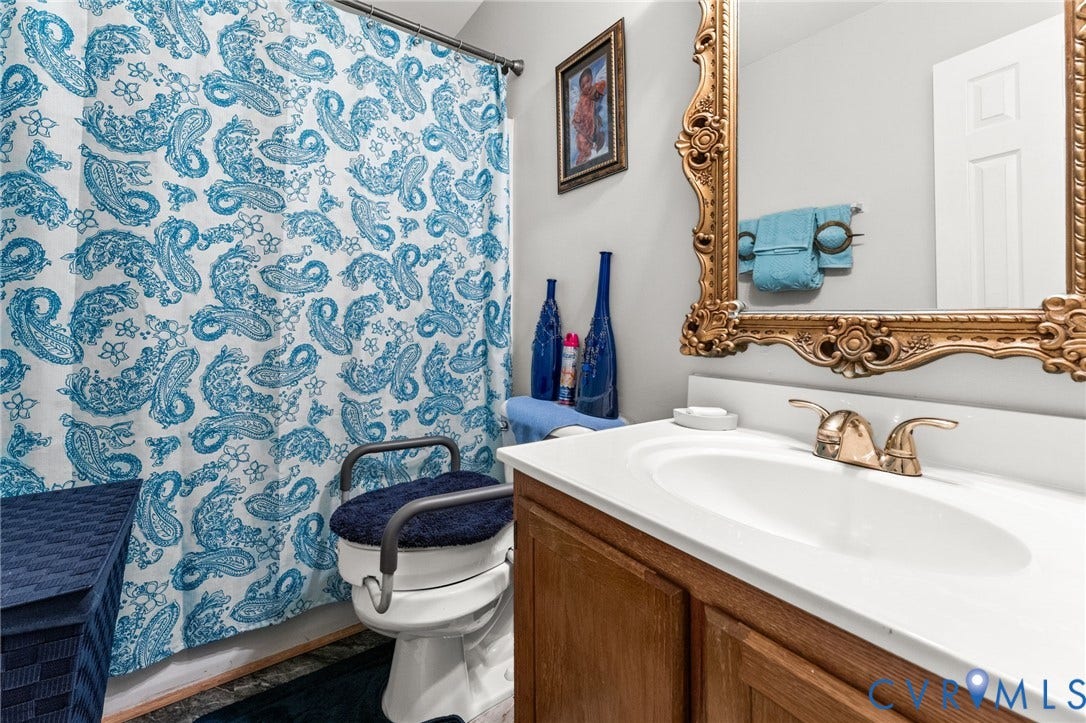 17030 Courtney Road, Reedy Church District, Hanover, VA 23069 Vanity featuring a wood-finish cabinet, integrated countertop with oval basin, and dual-handle metal faucet
