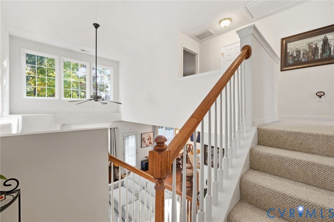 621 Scotter Hills Court, Midlothian, VA 23114 Staircase featuring a wooden handrail, white balusters, and carpeted treads, complemented by high-reaching windows and a ceiling-mounted fan