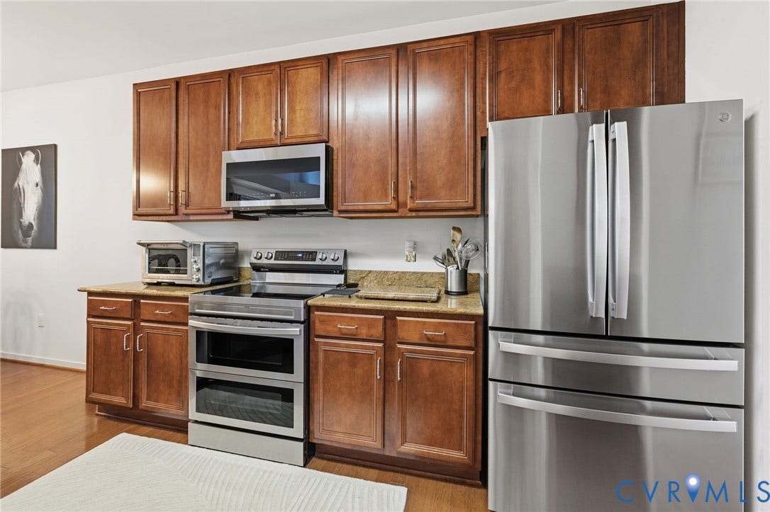 621 Scotter Hills Court, Midlothian, VA 23114 Kitchen featuring stained-wood cabinetry, stone countertops, and stainless steel appliances including a double-oven range, over-the-range microwave, and French-door refrigerator