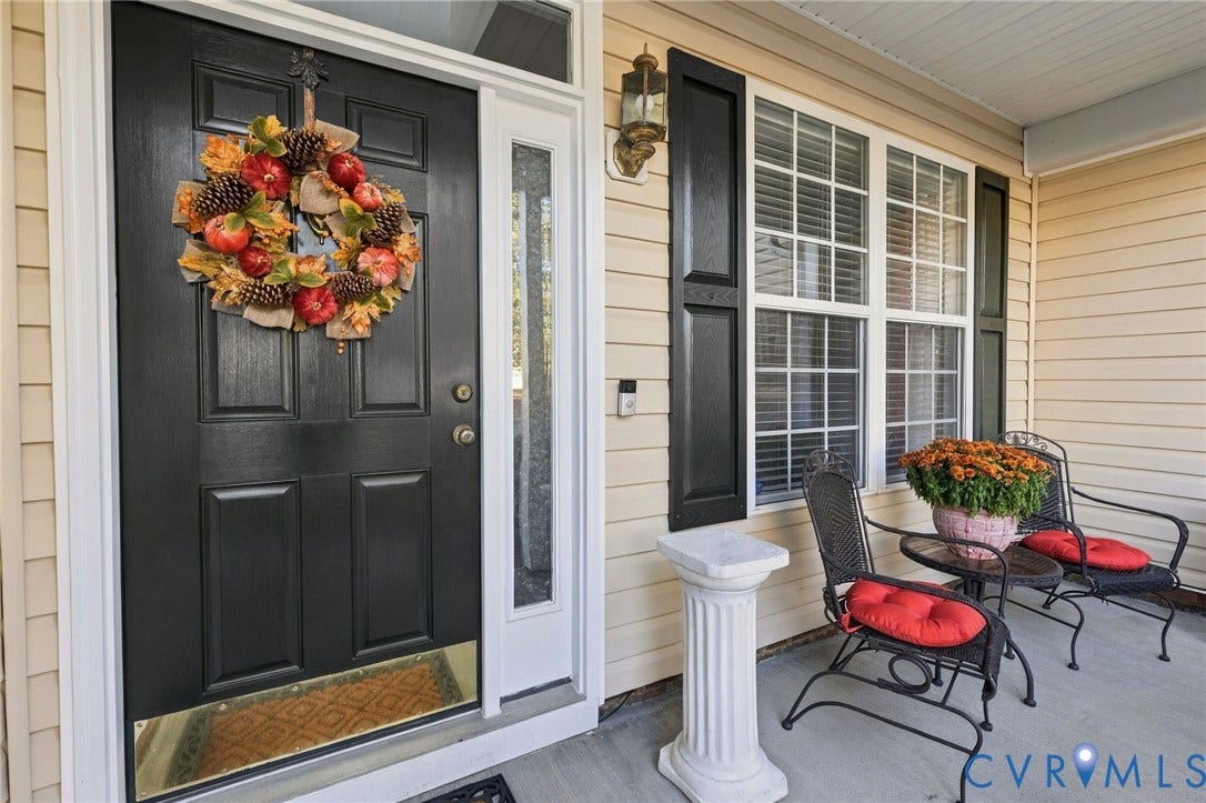 621 Scotter Hills Court, Midlothian, VA 23114 Covered entryway featuring horizontal lap siding, a paneled front door with a transom window and sidelight, and decorative window shutters