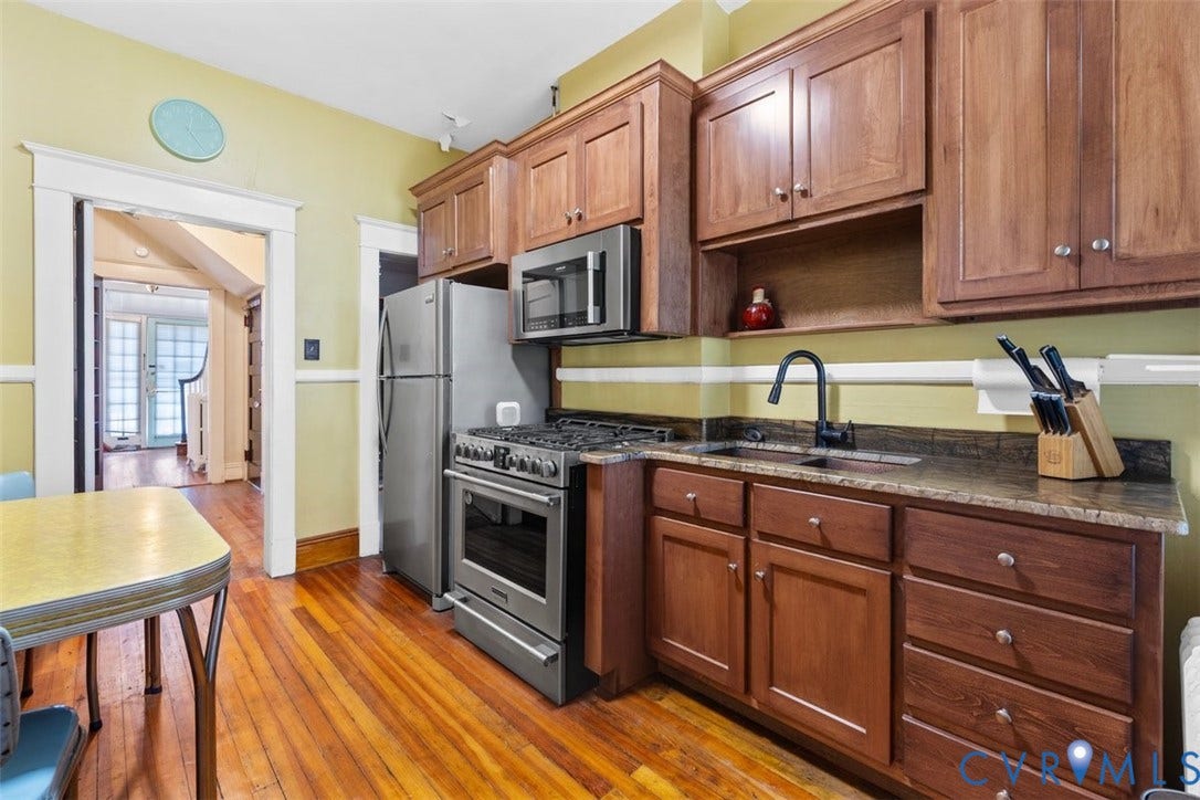 210 W Graham Road, Richmond, VA 23222 Kitchen featuring shaker-style wood cabinetry, stainless steel gas range, integrated microwave, stone-finish countertops, and wood-finish flooring