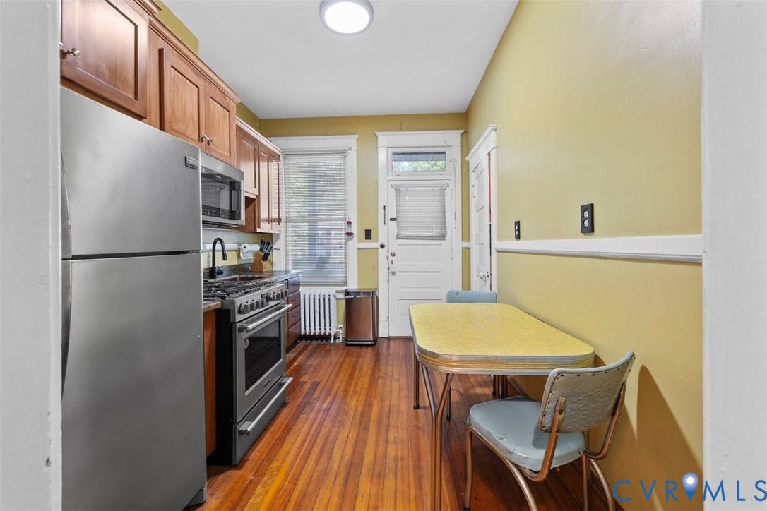210 W Graham Road, Richmond, VA 23222 Kitchen featuring wood-finish flooring, stainless steel appliances, stained wood cabinetry, and a high-arch faucet