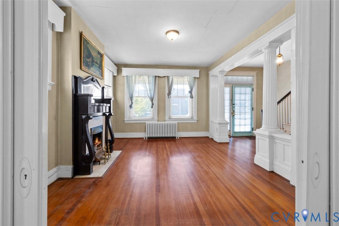 210 W Graham Road, Richmond, VA 23222 Hardwood flooring, decorative fireplace with an ornate mantel, classic architectural columns, and multi-pane entry door