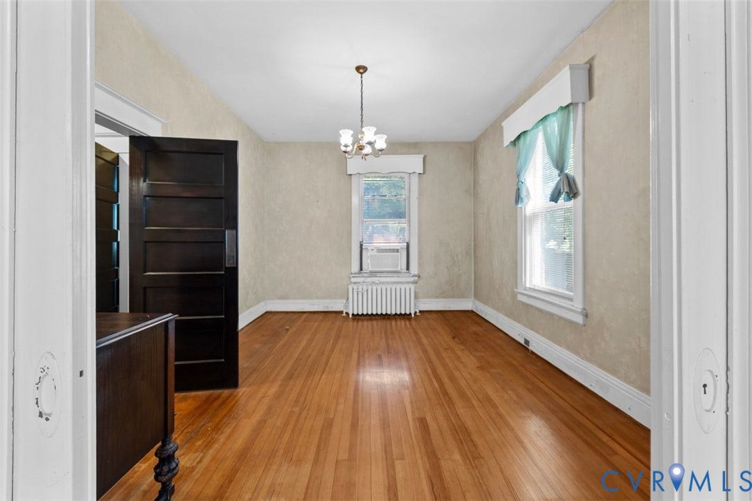 210 W Graham Road, Richmond, VA 23222 Hardwood flooring, multi-panel dark wood door, and central chandelier light fixture