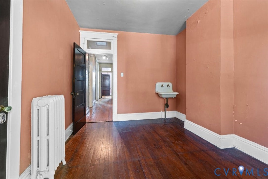 210 W Graham Road, Richmond, VA 23222 Third bedroom with wall-mounted basin, cast iron radiator, and solid wood interior door with transom window
