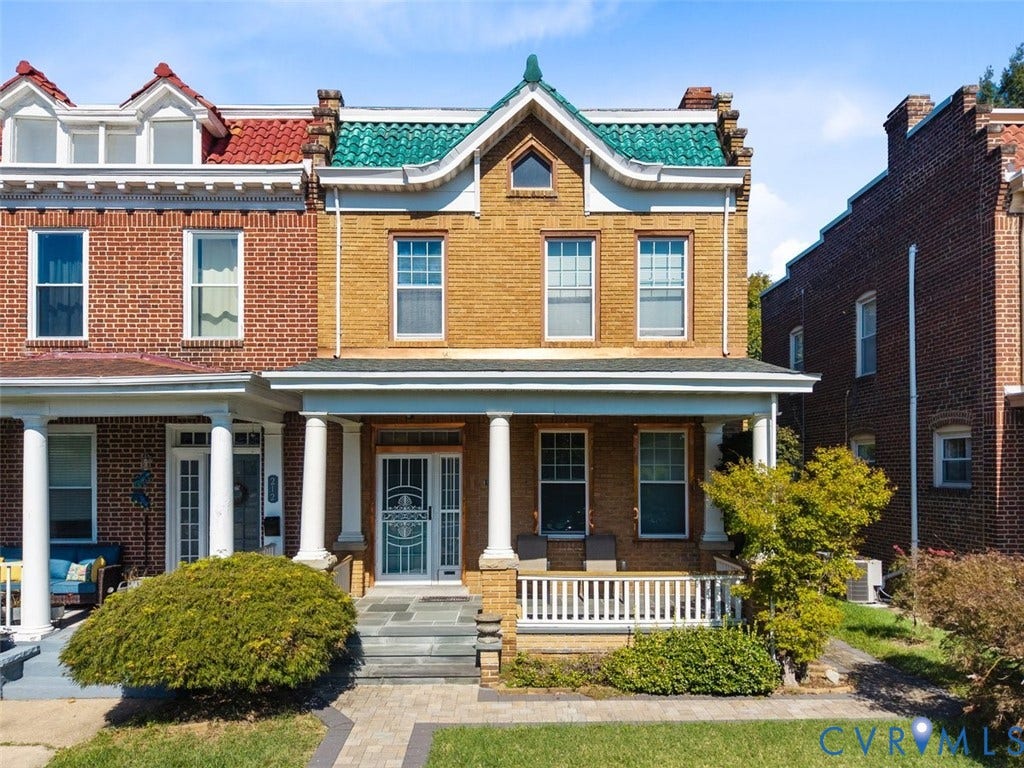 210 W Graham Road, Richmond, VA 23222 Brick facade exterior featuring a covered front porch with classic columns, a prominent green tile roof accent, stone-paved entry, and white decorative railing