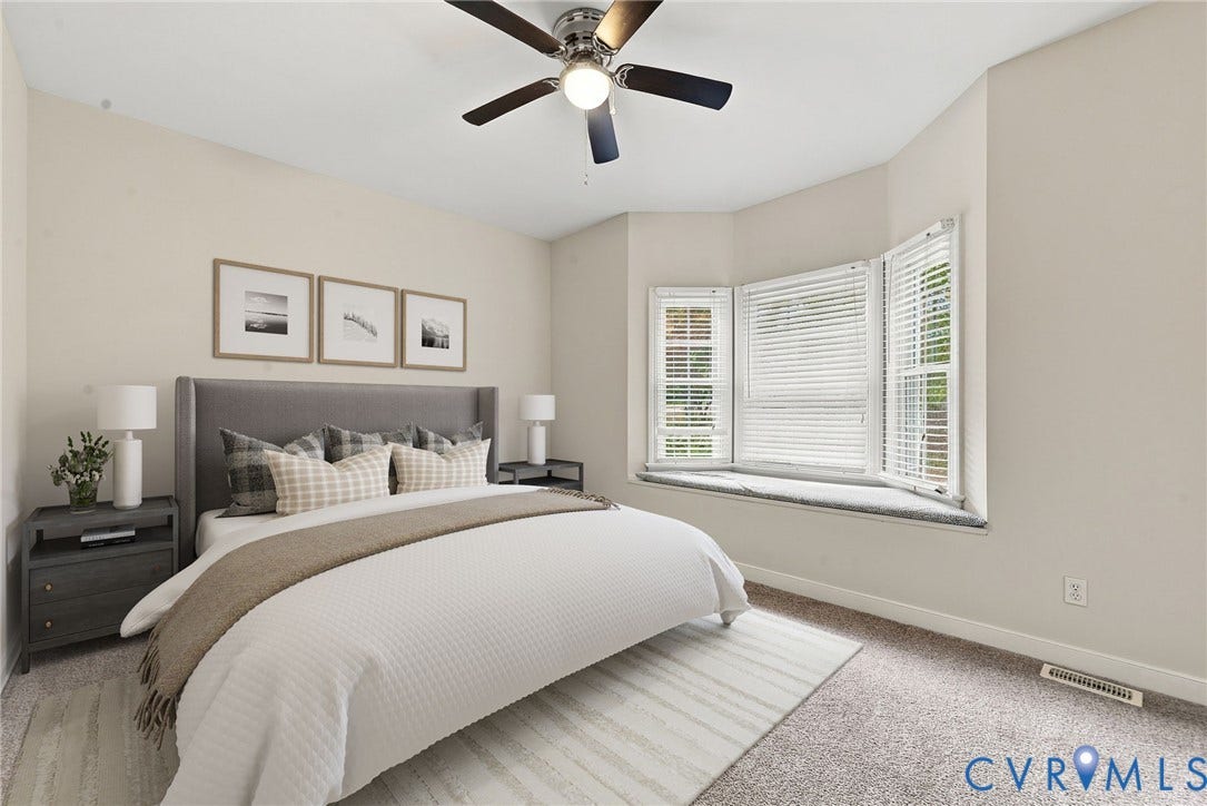 2654 Academy Road, Powhatan, VA 23139 Bedroom featuring neutral wall paint, wall-to-wall carpeting, a multi-panel bay window, a built-in window seat, and a central ceiling fan with integrated lighting. Virtually staged concept