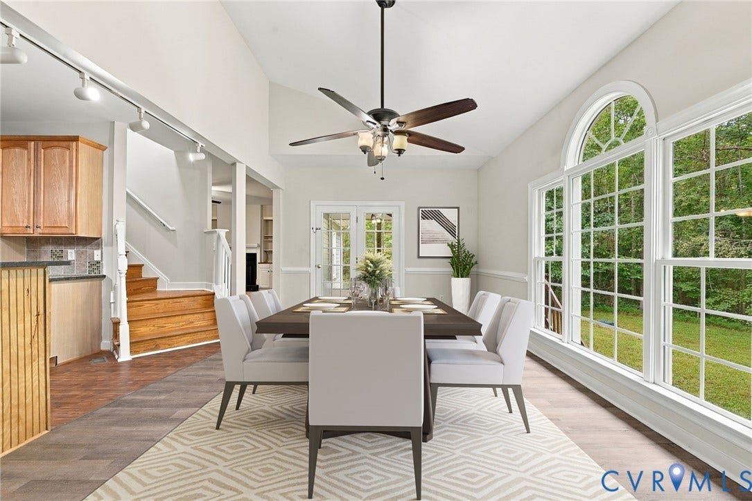 2654 Academy Road, Powhatan, VA 23139 Dining area featuring LVP flooring, a raised sloped ceiling, a multi-blade ceiling fan with integrated lighting, and a triple-pane window with an arched transom. Virtually staged concept