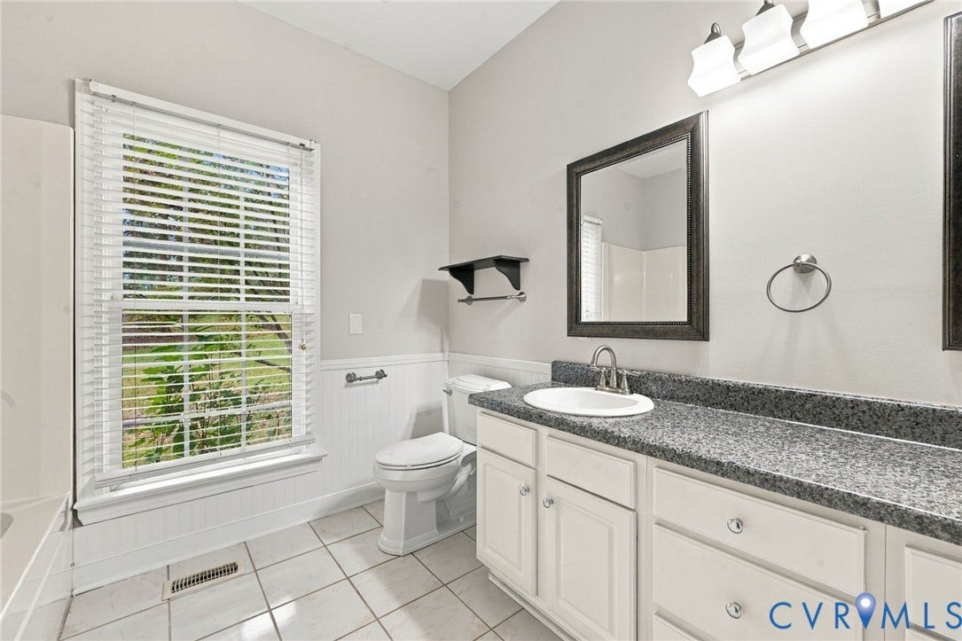 2654 Academy Road, Powhatan, VA 23139 Bathroom featuring a double-vanity, white cabinetry, tile flooring, beadboard wainscoting, and a wall-mounted light fixture