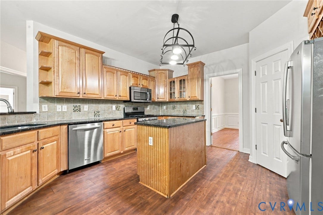 2654 Academy Road, Powhatan, VA 23139 Kitchen featuring wood cabinetry, a central island with beadboard detailing, granite countertops, and stainless-steel appliances