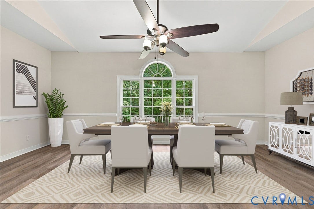 2654 Academy Road, Powhatan, VA 23139 Dining area featuring LVP flooring, a raised sloped ceiling, a multi-blade ceiling fan with integrated lighting, and a triple-pane window with an arched transom. Virtually staged concept