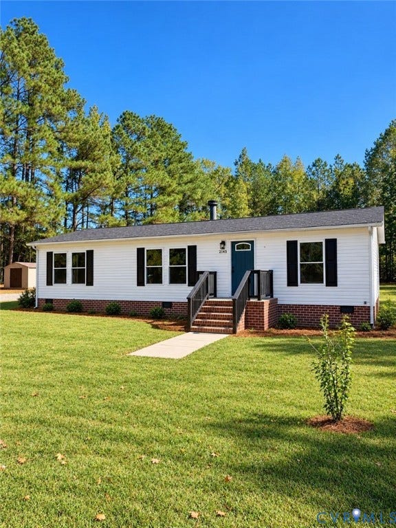 21145 Walkers Mill Road, Stony Creek, VA 23882 Single-story exterior featuring white vinyl siding, dark shutters, brick underpinning, and a concrete walkway leading to the entry steps