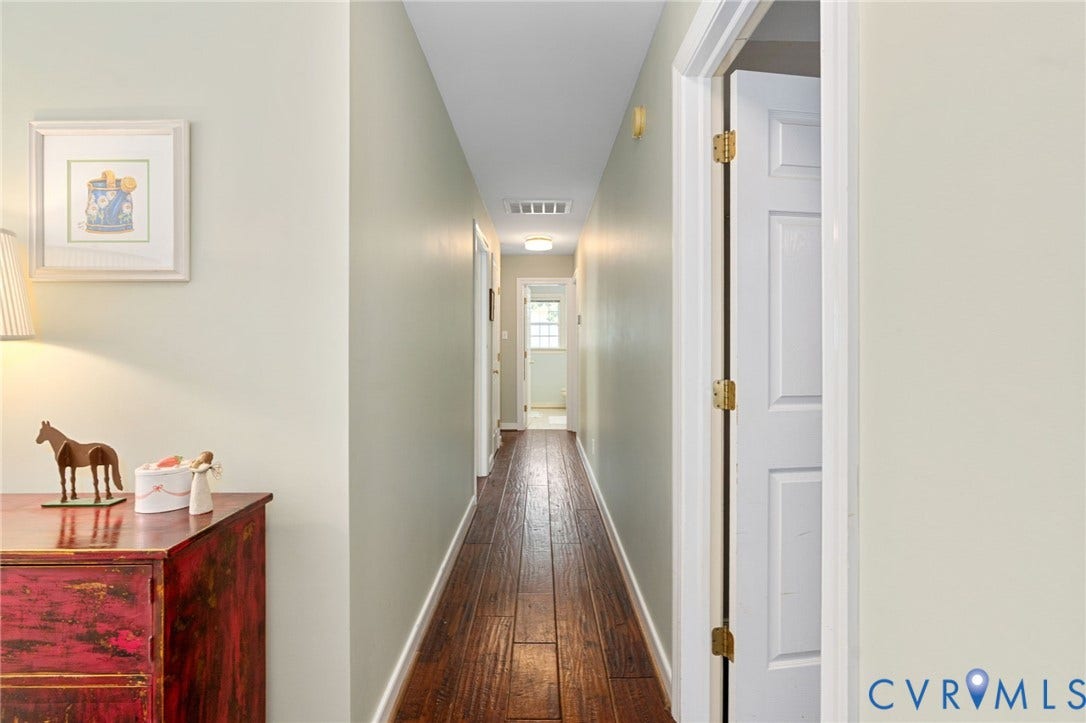 4427 Tweedsmuir Court, Midlothian, VA 23120 Hallway featuring wood-finish flooring, neutral wall paint, and multi-panel interior doors with brass-tone hardware