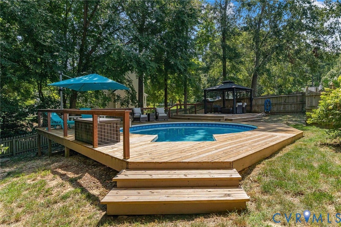 4427 Tweedsmuir Court, Midlothian, VA 23120 Multi-level wooden decking featuring an integrated pool, built-in staircase, wood railing, and a permanent metal-framed gazebo