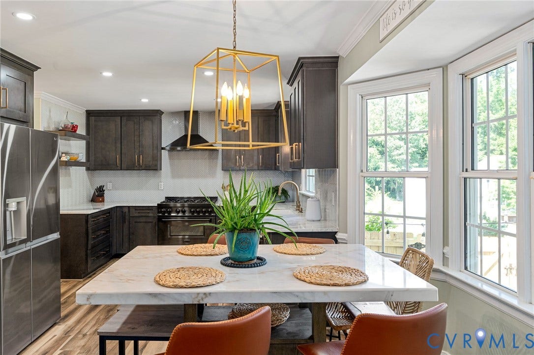 4427 Tweedsmuir Court, Midlothian, VA 23120 Kitchen featuring dark cabinetry, stone-surface island, metal geometric chandelier, stainless steel appliances, and bay windows