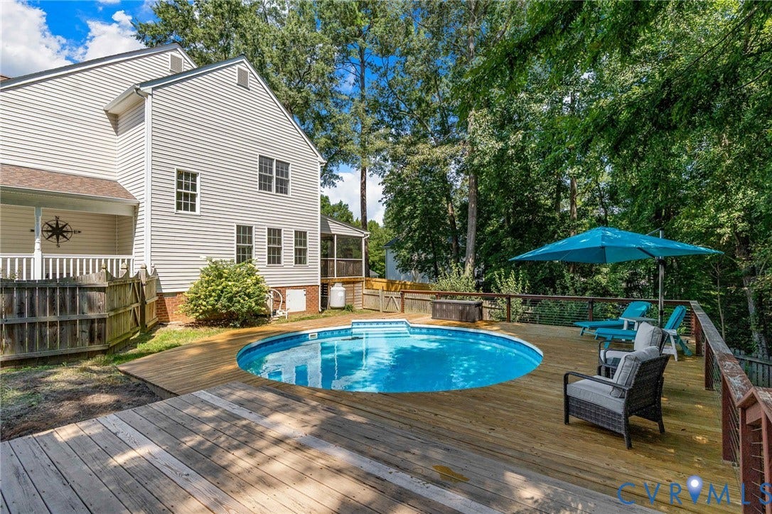 4427 Tweedsmuir Court, Midlothian, VA 23120 Rear exterior featuring a multi-level wood deck, an above-ground swimming pool, vinyl siding, and mature tree-lined perimeter