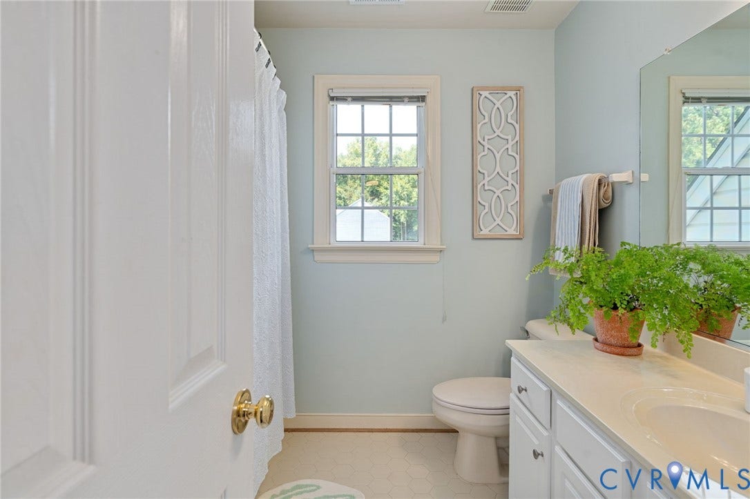 4427 Tweedsmuir Court, Midlothian, VA 23120 Bathroom featuring a white vanity cabinet, solid-surface countertop with an integrated sink, large wall-mounted mirror, and a double-hung window