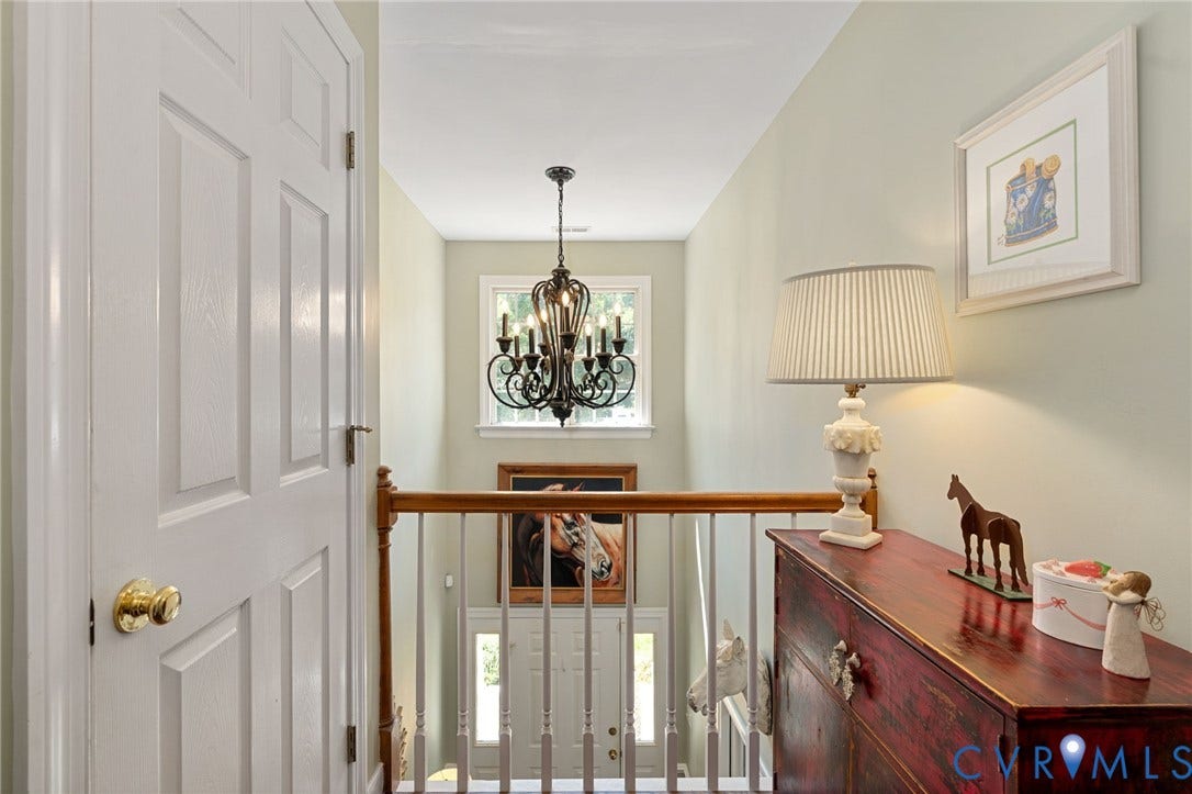 4427 Tweedsmuir Court, Midlothian, VA 23120 Multi-level interior featuring a decorative metal chandelier, wood-finish stair railing with vertical balusters, and multi-pane window