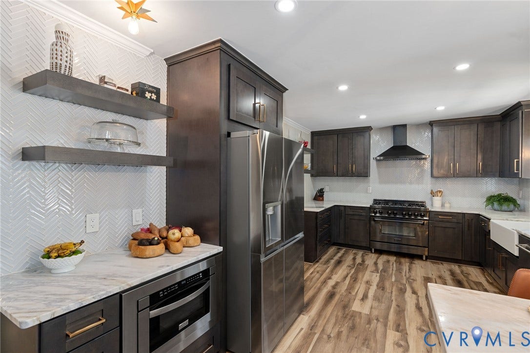 4427 Tweedsmuir Court, Midlothian, VA 23120 Kitchen featuring dark-finish cabinetry, stone-finish countertops, stainless steel appliances, a white farmhouse sink, and a herringbone-patterned tile backsplash