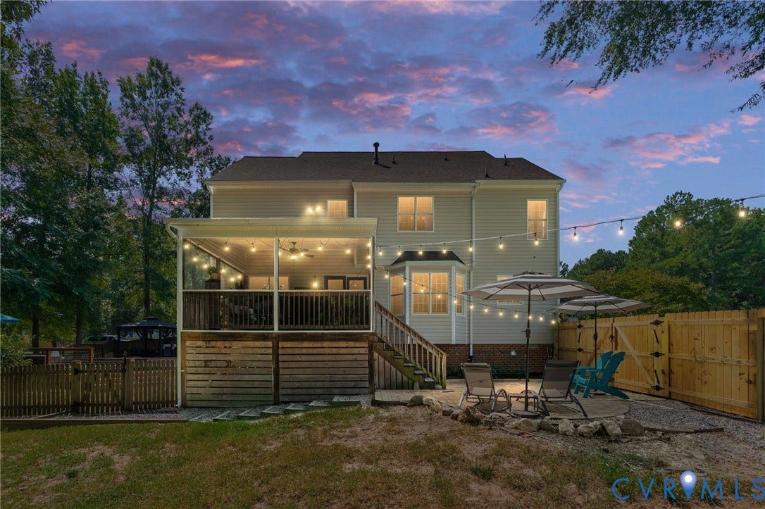 4427 Tweedsmuir Court, Midlothian, VA 23120 Exterior rear elevation featuring a covered back porch with a ceiling fan, a gravel patio, and wood privacy fencing
