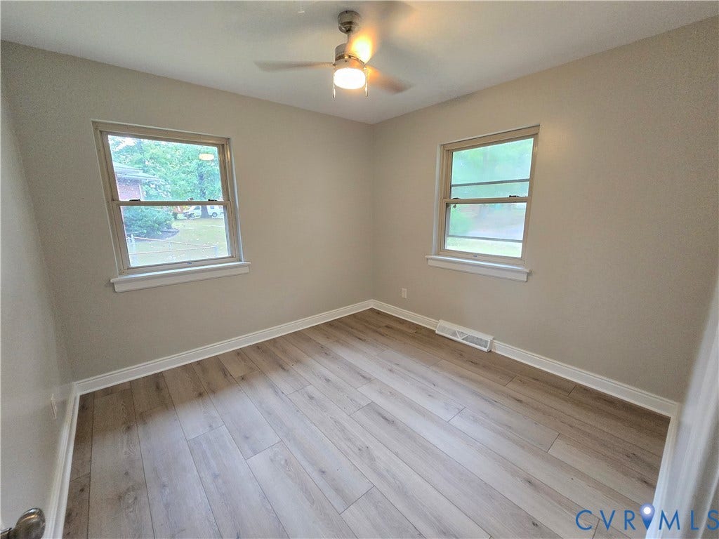 1108 Pierpont Road, Richmond, VA 23225 Primary bedroom with LVP flooring, two windows with natural light, and a central ceiling fan with an integrated light fixture