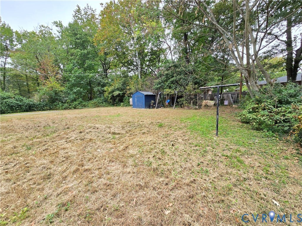 1108 Pierpont Road, Richmond, VA 23225 Expansive backyard featuring mature trees, a metal storage shed, and a permanent clothesline pole