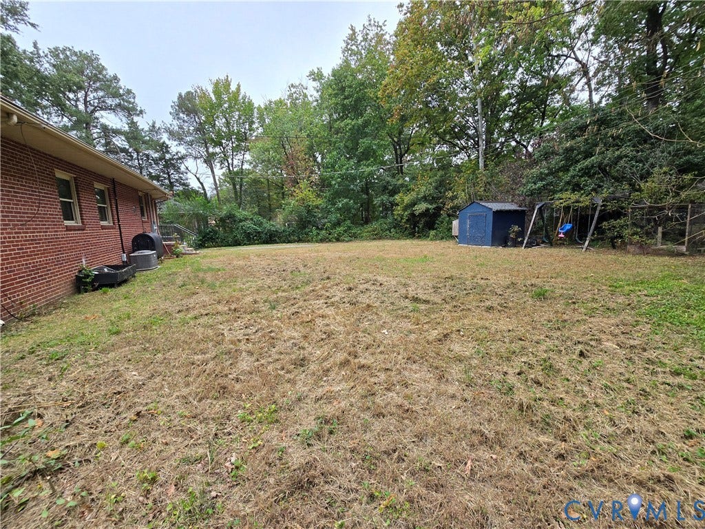 1108 Pierpont Road, Richmond, VA 23225 Expansive backyard featuring a brick exterior facade, mature trees, and peripheral landscaping