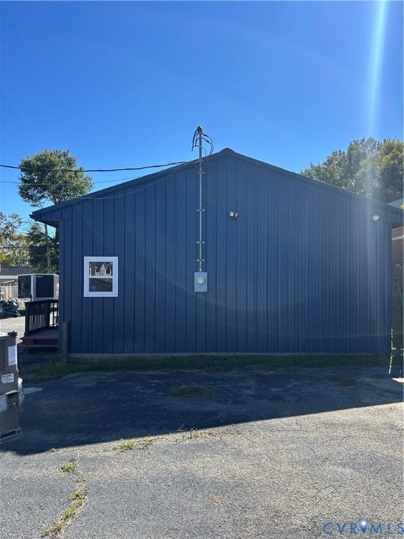 3300 Hull Street, Richmond, VA 23224 Exterior featuring dark blue vertical metal siding, an asphalt paved lot, and a white-framed window