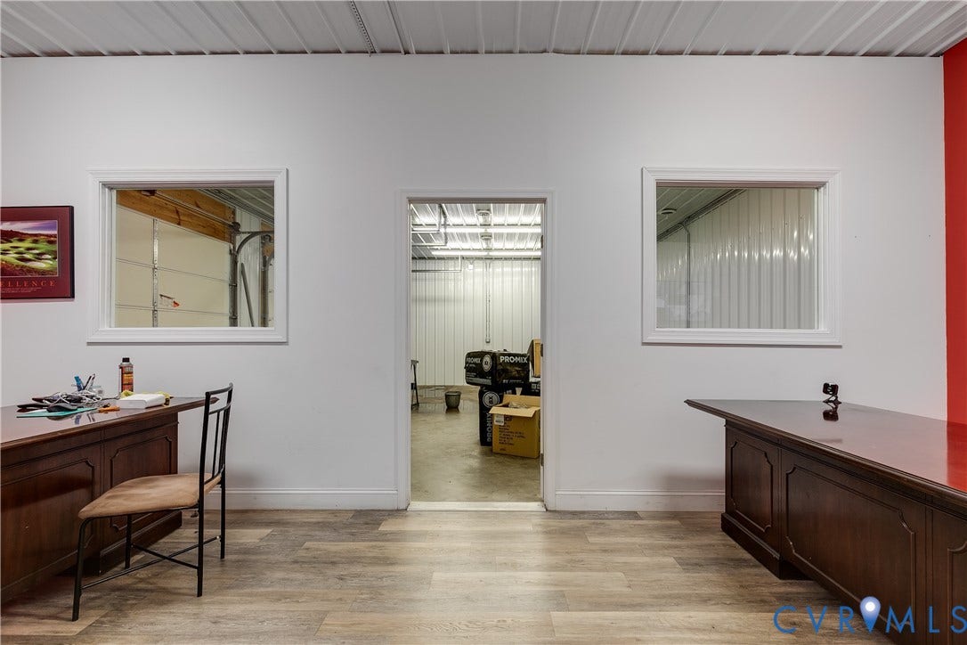 3300 Hull Street, Richmond, VA 23224 Interior space featuring wood-finish flooring, white walls, two windows with white trim, and a central open doorway