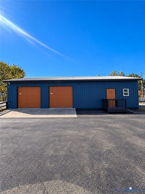 3300 Hull Street, Richmond, VA 23224 Detached metal-sided structure featuring two garage bays, a paved apron, and an elevated entry platform with railing